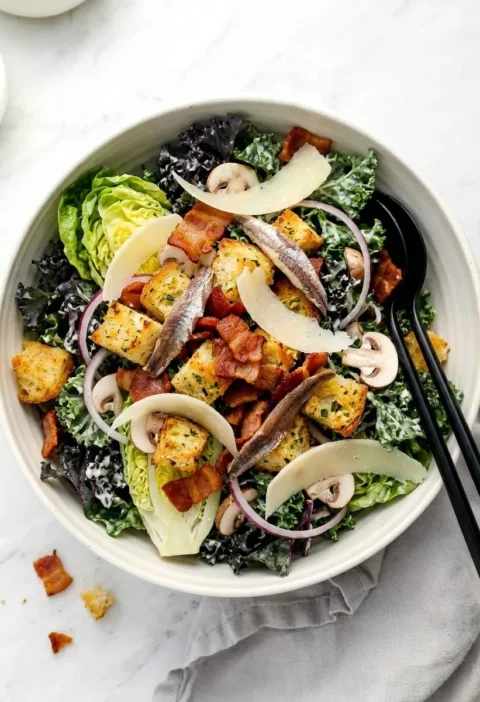 Kale caesar salad with bacon lardons, sourdough croutons, anchovies and Parmesan shavings
