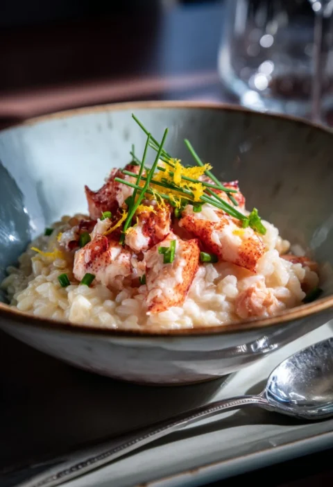 Gordon Ramsay lobster risotto in a bowl with lobster chunks, chives and lemon zest