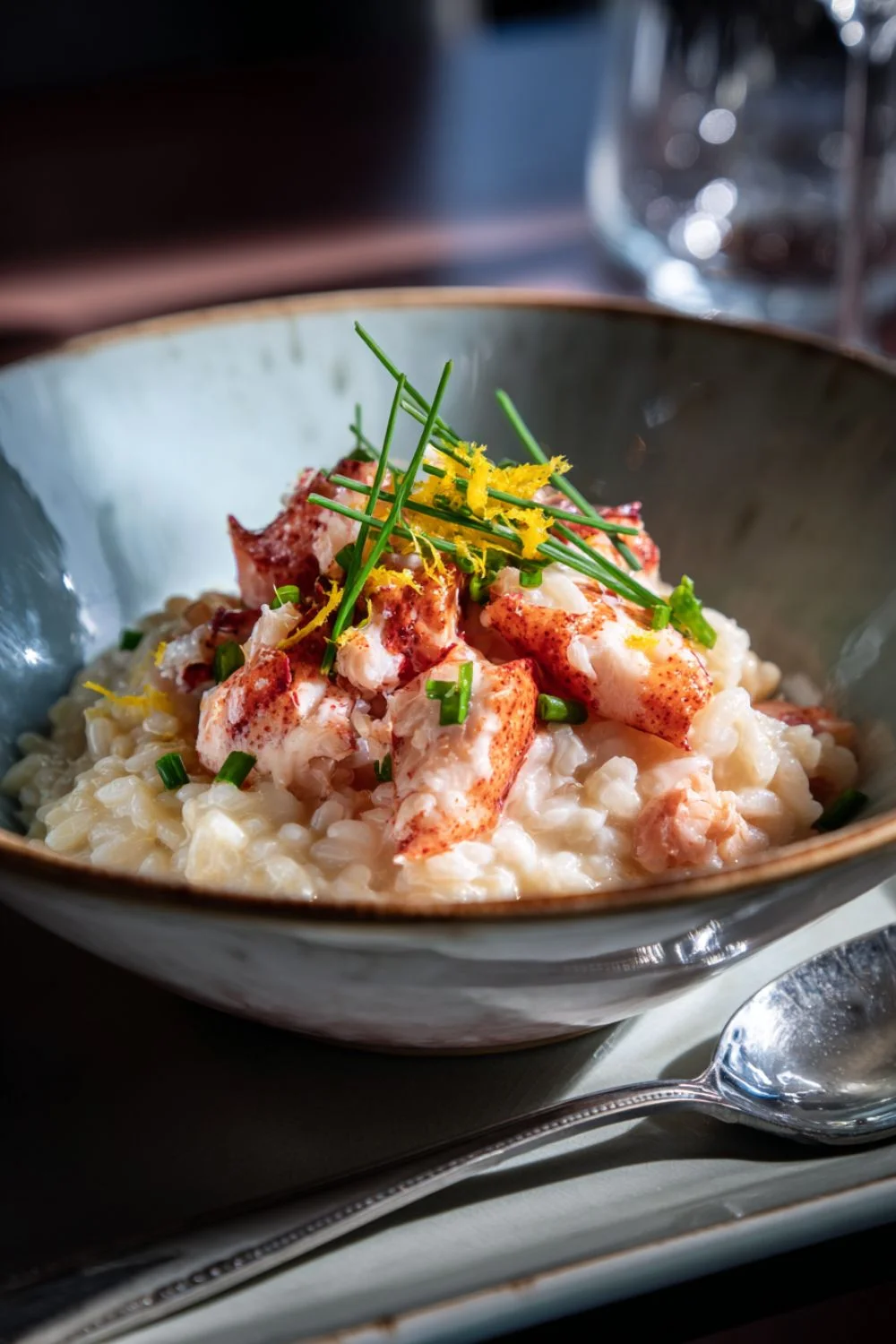 Gordon Ramsay lobster risotto in a bowl with lobster chunks, chives and lemon zest
