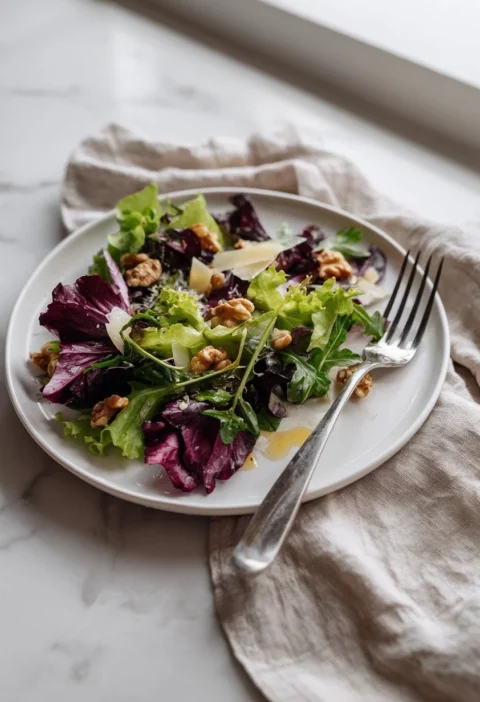 Gordon Ramsay rocket salad with radicchio walnuts and Parmesan shavings on a plate