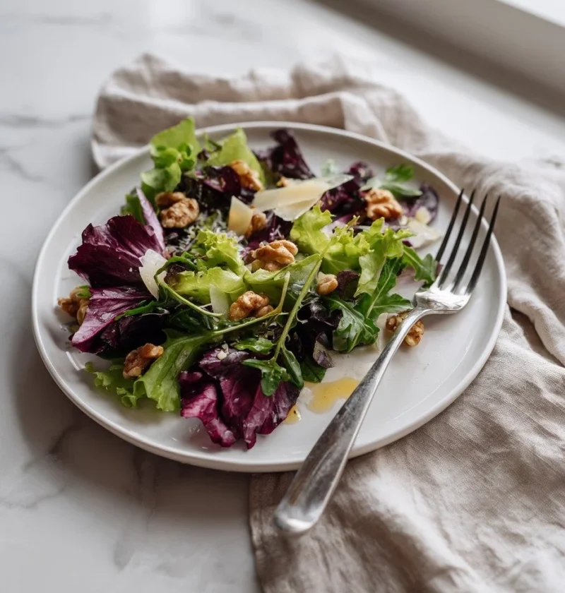 Gordon Ramsay rocket salad with radicchio walnuts and Parmesan shavings on a plate