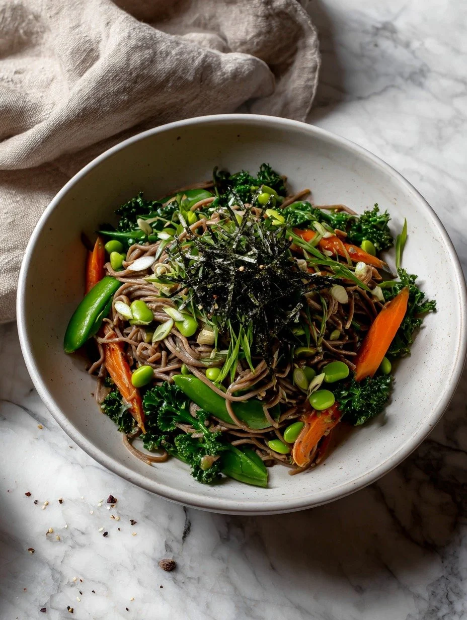 Overhead view of soba noodle salad showing sugarsnap peas, carrots, kale and sesame