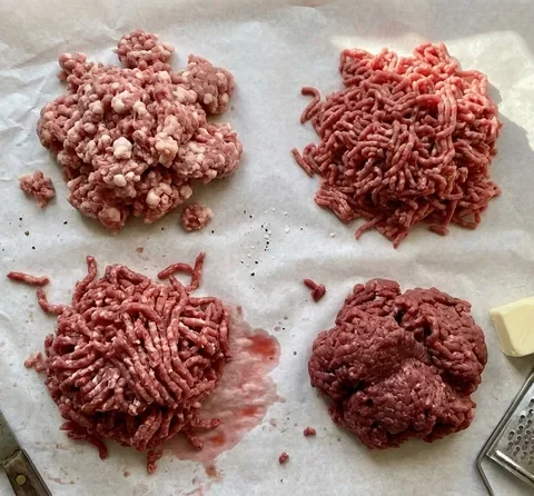 Four burger meat blends compared side by side on butcher paper: fatty BSK-style mix, standard mince, coarse butcher grind, and lean mince with frozen butter and grater