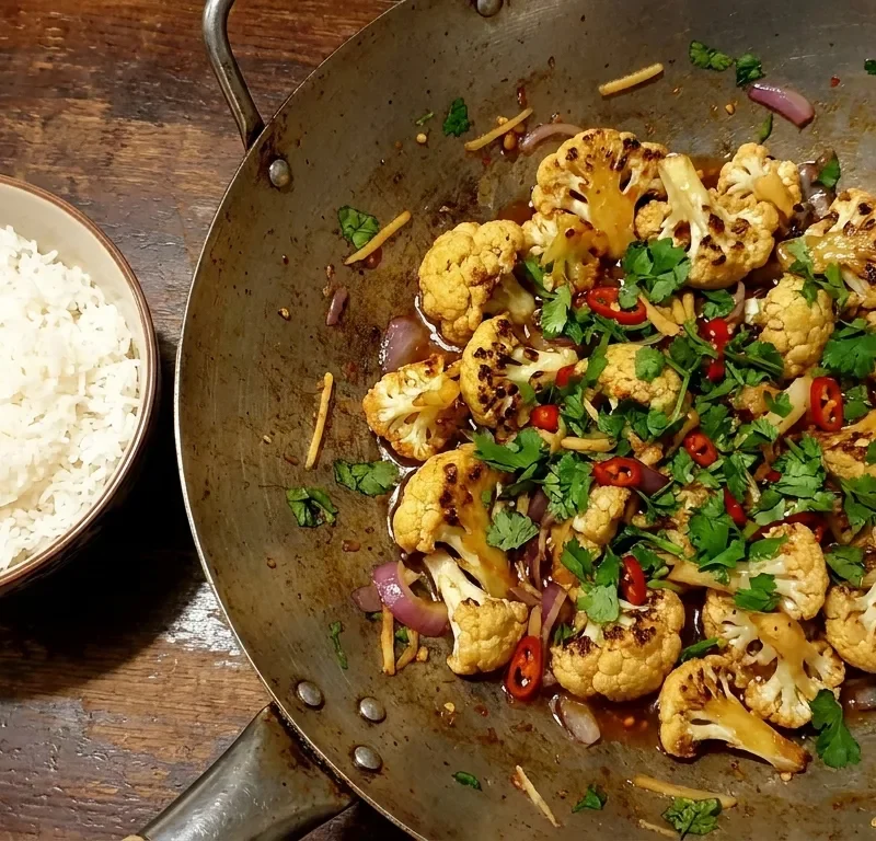 Gordon Ramsay bang bang cauliflower in a wok with charred florets, sweet chilli sauce, coriander, red chilli and ginger with rice