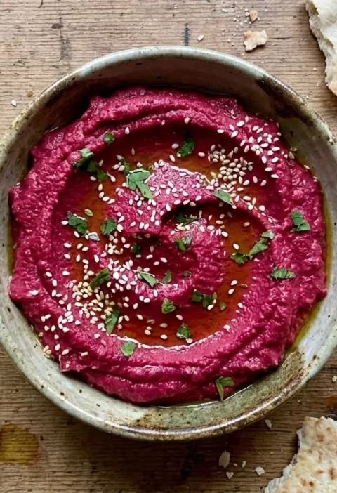 Gordon Ramsay beetroot hummus with za'atar sprinkle sesame seeds and marjoram in a ceramic bowl with torn pitta bread and lemon