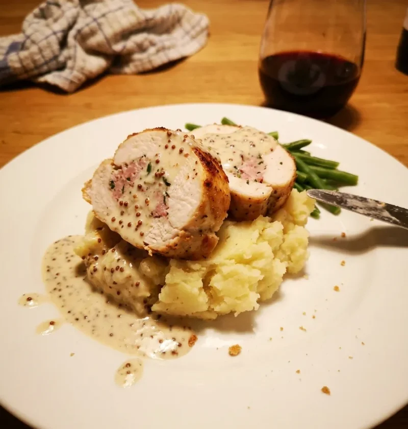 Gordon Ramsay chicken ballotine sliced into rounds on mashed potato with wholegrain mustard veloute and green beans