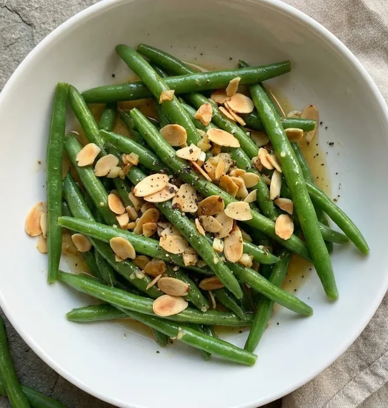 Gordon Ramsay green beans with mustard dressing topped with toasted flaked almonds in a roasted garlic dressing
