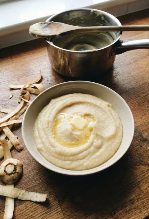 Gordon Ramsay parsnip puree with melting butter in a bowl on a wooden worktop