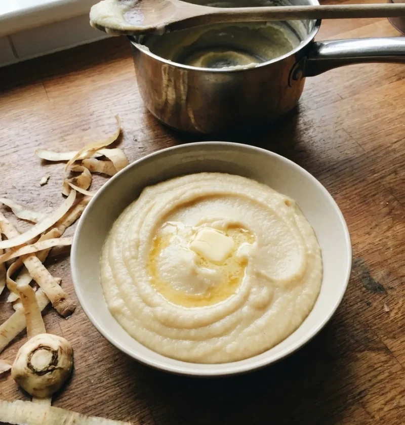 Gordon Ramsay parsnip puree with melting butter in a bowl on a wooden worktop
