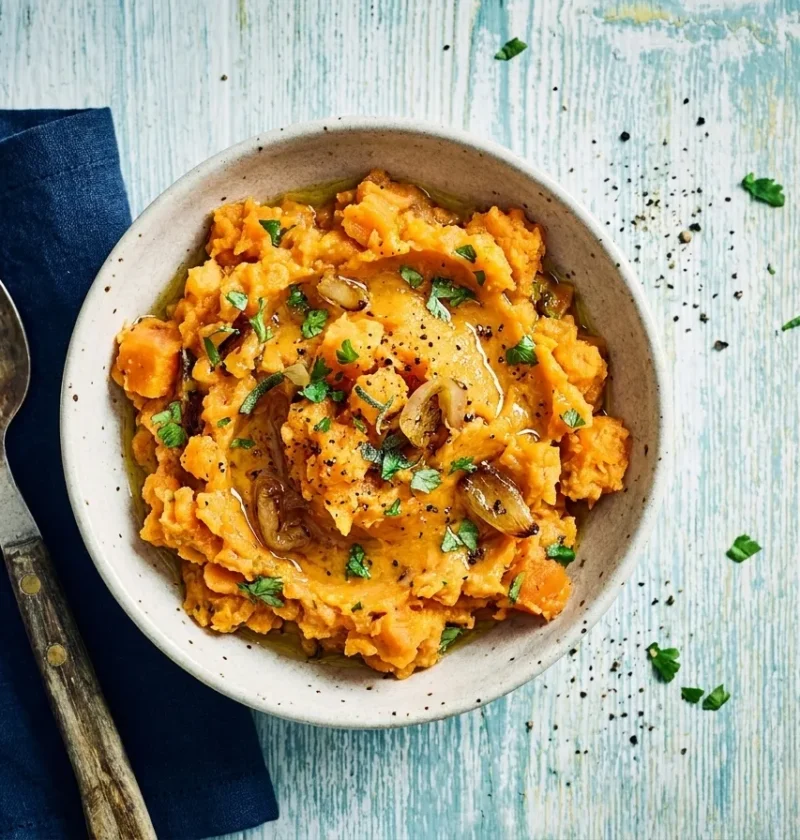 Gordon Ramsay sweet potato mash crushed with caramelized shallots coriander and sage in a speckled bowl
