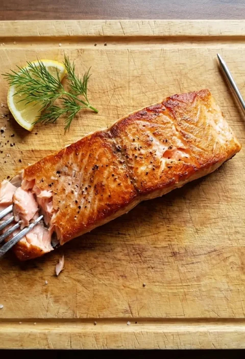Cooked salmon fillet flaked open with a meat thermometer, salmon cooking times and temperatures