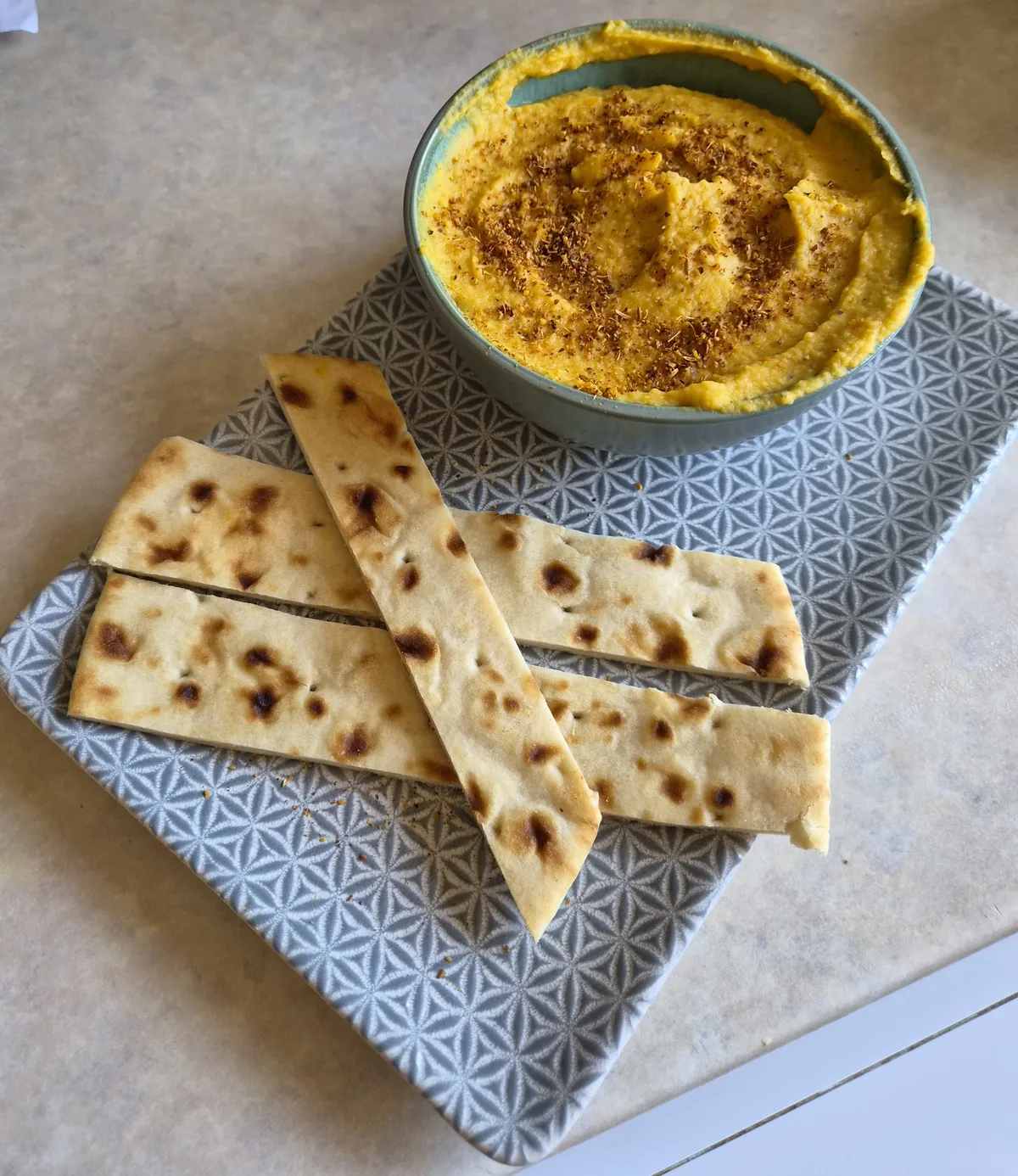Butternut squash hummus in a green bowl dusted with ras el hanout, served with flatbread strips, cooked and photographed by reader Alex Sunins