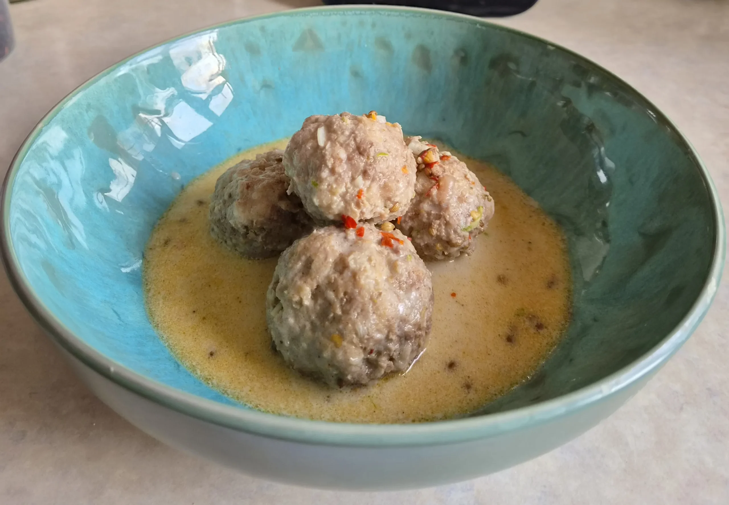Meatballs in coconut broth cooked and photographed by reader Alex Sunins