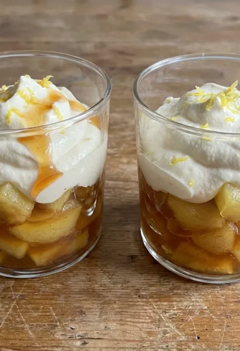 Gordon Ramsay apple compote layered in glasses with caramelised apple chunks under whipped cream and lemon zest