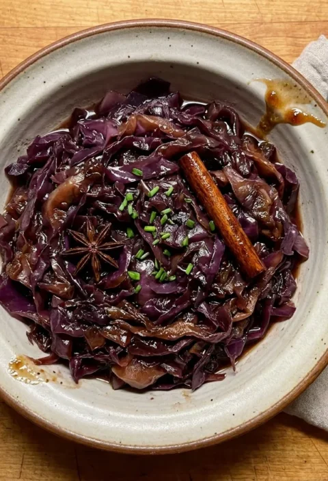 Gordon Ramsay braised red cabbage, glossy shredded cabbage in a syrupy port glaze with a cinnamon stick, star anise and chopped chives
