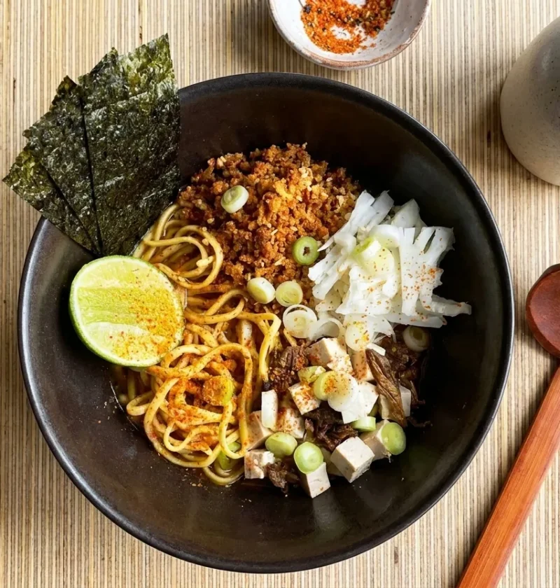 Gordon Ramsay cauliflower ramen with crispy fried cauliflower, tofu, egg noodles, nori and shichimi lime in a dark bowl
