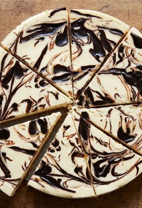 Gordon Ramsay chocolate swirl cheesecake cut into wedges showing dark chocolate ribbons marbled through the pale filling