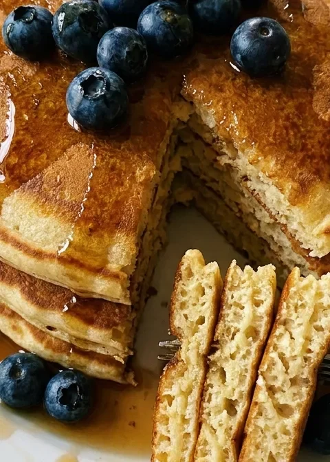 Gordon Ramsay fluffy buttermilk pancakes stacked with blueberries and maple syrup on a white plate