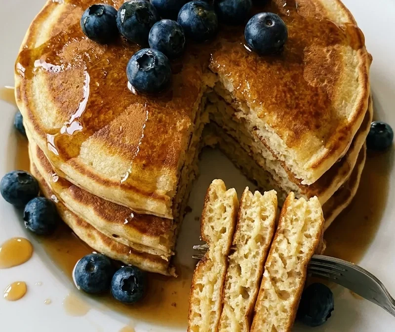 Gordon Ramsay fluffy buttermilk pancakes stacked with blueberries and maple syrup on a white plate